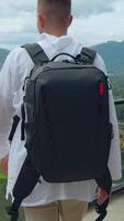Man with view of tropical mountain valley. Action. Man on observation deck in tropical mountains. Man with backpack on sightseeing attraction overlooking green mountains video