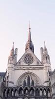 Bottom view of European Gothic Palace on background of sky. Action. Beautiful symmetrical architecture of Gothic Palace is landmark in Europe video