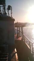 A view of a barge ship transporting goods. Clip. Ship on rippling river with shining sun on the background. video