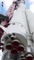 View of bottom of rocket on background of sky. Action. Realistic monument of white Vostok rocket with nozzles towering up to blue sky video