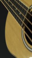 cerca arriba de clásico guitarra con acero instrumentos de cuerda en negro fondo, música concepto. valores imágenes. fondo ver de de madera acústico guitarra, nuevo instrumento. video