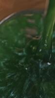 Top view of glass of champagne on wooden table background, celebration concept. Stock footage. Close up of amazing alcoholic beverage with shining particles being poured into the glass. video