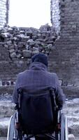 Rear view of a man in a wheelchair for the disabled in the ruined Church. Footage. The concept of loss video