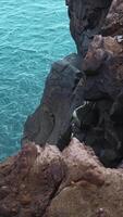 Beautiful rocks by water. Clip. Stone cliffs of coast with quiet sea water. View from edge of stone shore to sea water video