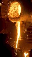 Smelting works at plant. Scene. Jet of alloy is poured out and sparks are carried in different directions at smelter. Bright hot stream of alloy flows and sparkles video