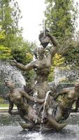 Beautiful old fountain with sculptures in Park. Action. Sculptural composition with mermaids in fountain on background of green Park video