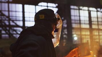 An Industrial Worker Dressed in Protective Gear is Overseeing the Melting Process at Work. Stock Clip video