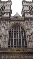 Facade of cathedral with two towers on background of cloudy sky. Action. View from bottom of beautiful cathedral building with gothic architecture in cloudy weather video