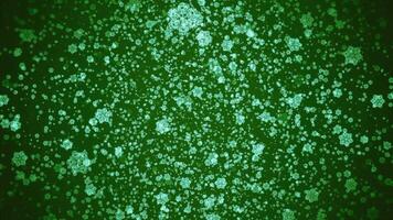 White blurred large and tiny snowflakes that fall down on a green background. Motion. Merry Christmas, winter holiday and Happy New Year greeting concept. video