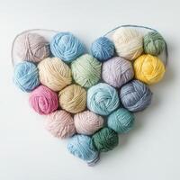 Colorful yarn balls arranged in a heart shape on a light background for crafting lovers photo