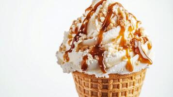 Soft serve ice cream topped with caramel drizzle and crushed nuts in a waffle cone photo