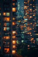 City skyline at dusk with illuminated apartment windows surrounded by trees photo