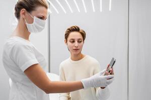 A young woman shows examples of the job she wants to get on her smartphone. Beauty salon. photo