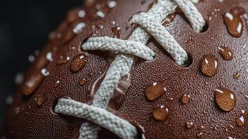 A close-up of a wet football showcasing water droplets on its surface during a rainy game photo