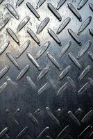 Close-up view of textured metal sheet with diamond pattern and reflective surface photo