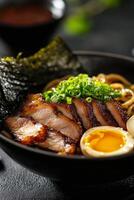 Delicious bowl of ramen topped with grilled chicken, green onions, and a soft-boiled egg photo