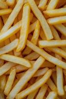 Golden fried potatoes scattered on a bright yellow surface for a delightful snack experience photo