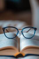 Glasses resting on an open book in a library setting during daytime photo