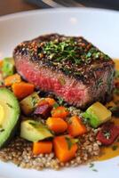 Delicious grilled steak served on a bed of quinoa with vibrant vegetables and avocado slices photo