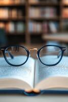 Glasses resting on an open book in a library setting during daytime photo