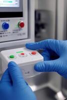 Close-up of a gloved hand holding a remote control device with colored buttons in a clinical setting photo