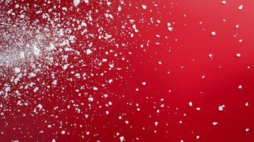 Snowflakes gently falling against a vibrant red background during the festive holiday season photo