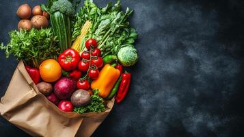 Freshly harvested vegetables and fruits in a paper bag on a dark textured surface photo