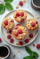 Freshly baked raspberry muffins with oats displayed on a plate surrounded by coffee photo