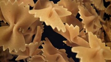 Farfale pasta flies in and falls. Filmed on a high-speed camera at 1000 fps. High quality FullHD footage video