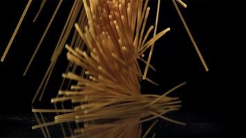 Dry spaghetti falling on a black background. Filmed on a high-speed camera at 1000 fps. High quality FullHD footage video