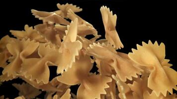 Farfale pasta flies in and falls. Filmed on a high-speed camera at 1000 fps. High quality FullHD footage video