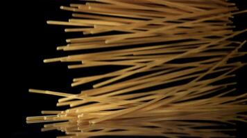 Dry spaghetti falling on a black background. Filmed on a high-speed camera at 1000 fps. High quality FullHD footage video