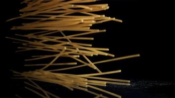Dry spaghetti falling on a black background. Filmed on a high-speed camera at 1000 fps. High quality FullHD footage video