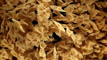 Farfale pasta flies in and falls. Filmed on a high-speed camera at 1000 fps. High quality FullHD footage video