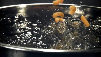 The pasta falls into the boiling water with splashes. Filmed on a high-speed camera at 1000 fps. High quality FullHD footage video