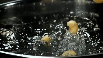 The pasta falls into the boiling water with splashes. Filmed on a high-speed camera at 1000 fps. High quality FullHD footage video