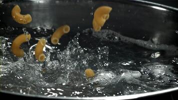 The pasta falls into the boiling water with splashes. Filmed on a high-speed camera at 1000 fps. High quality FullHD footage video