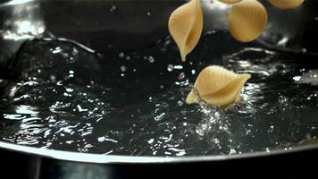 The pasta falls into the boiling water with splashes. Filmed on a high-speed camera at 1000 fps. High quality FullHD footage video