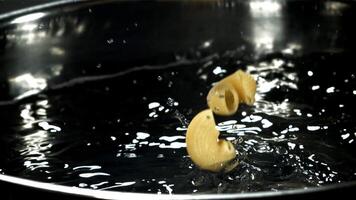 The pasta falls into the boiling water with splashes. Filmed on a high-speed camera at 1000 fps. High quality FullHD footage video