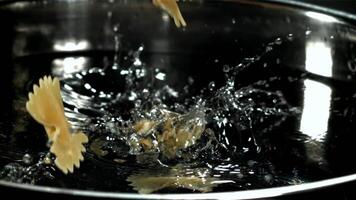 Farfalle pasta falls into boiling water. Filmed on a high-speed camera at 1000 fps. High quality FullHD footage video