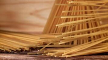 Spaghetti falling on a wooden table. Filmed on a high-speed camera at 1000 fps. High quality FullHD footage video