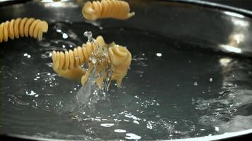 The pasta falls into the boiling water with splashes. Filmed on a high-speed camera at 1000 fps. High quality FullHD footage video