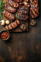 Delicious grilled steaks with spices and herbs arranged on a wooden cutting board photo