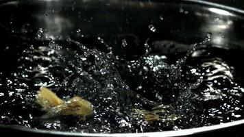 Farfalle pasta falls into boiling water. Filmed on a high-speed camera at 1000 fps. High quality FullHD footage video