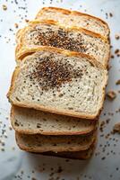 Slices of whole grain bread topped with seeds on a wooden cutting board photo