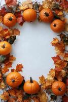 Autumn pumpkins surrounded by colorful leaves on a white background photo