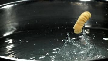 Fusilli pasta falls into boiling water. Filmed on a high-speed camera at 1000 fps. High quality FullHD footage video