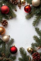 Christmas decorations featuring red ornaments and pine branches arranged on a white surface photo