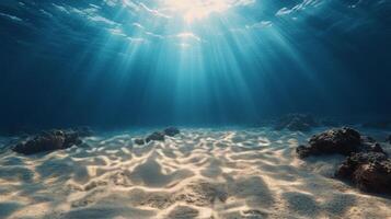 Sunlight filtering through clear turquoise water reveals a sandy ocean floor with coral formations photo