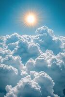 Bright sun shining through fluffy clouds in a clear blue sky photo